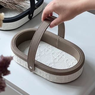 Oval-shaped leather jacquard tray with handlein .