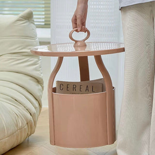 Round storage side table with handlein  includes magazine rack.