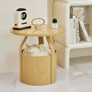 Round storage side table with handlein  includes magazine rack.