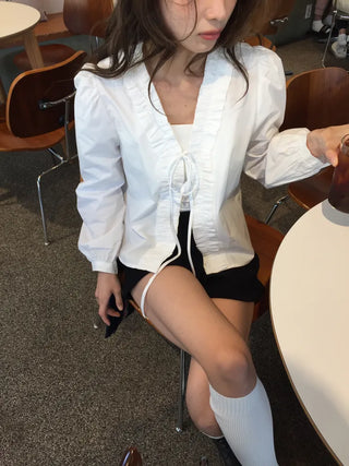A delicate blouse completed with a single ribbon