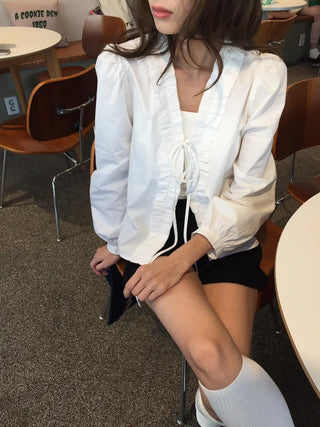 A delicate blouse completed with a single ribbon