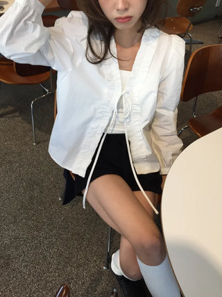 A delicate blouse completed with a single ribbon