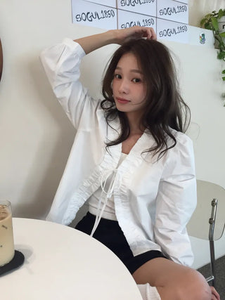 A delicate blouse completed with a single ribbon