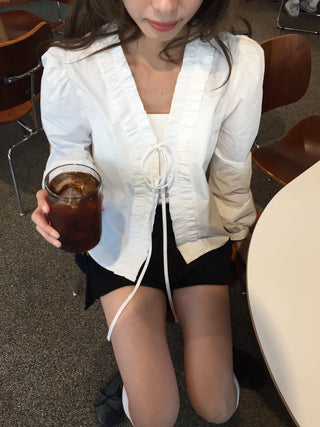 A delicate blouse completed with a single ribbon