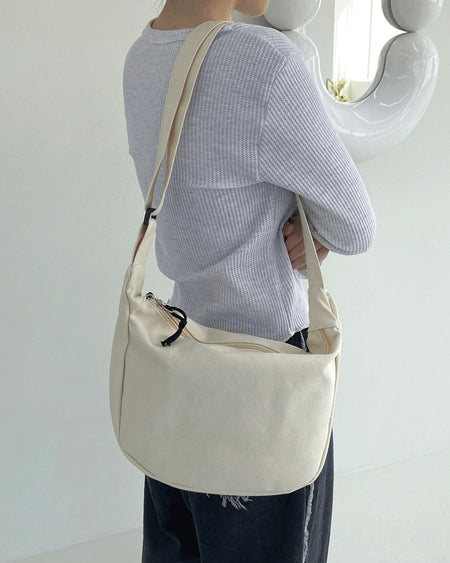 Leant canvas half-moon cross-body bag
